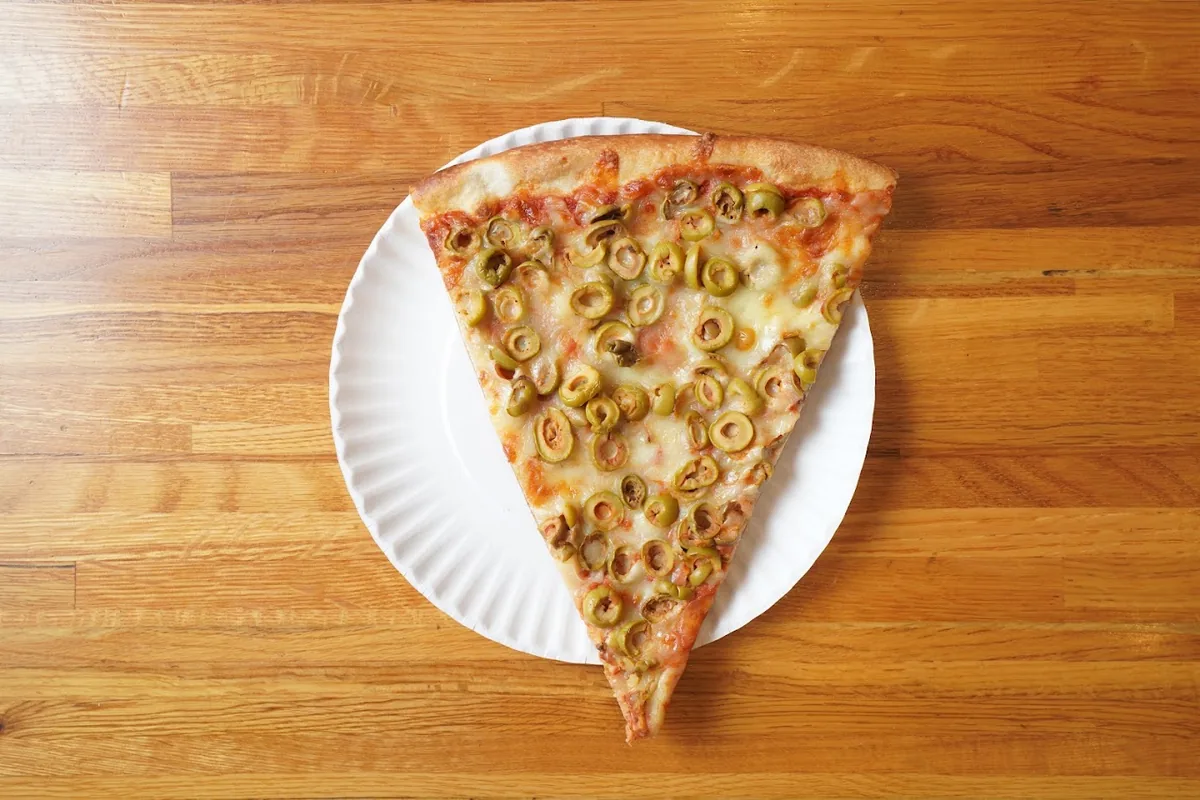 Signature NYC pizza slice with crispy crust at Pizza Palace Cafe Forest Hills